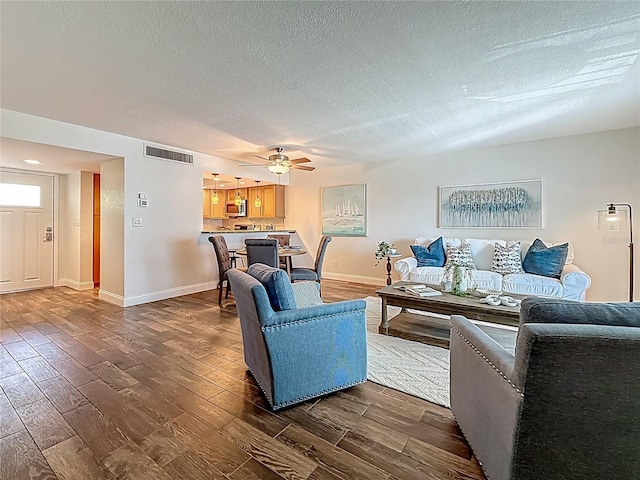 105 4th Ave NE Unit 426, Saint Petersburg, FL 33701 - living area featuring dark wood finished floors, a textured ceiling, and a ceiling fan