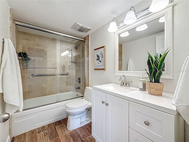 105 4th Ave NE Unit 426, Saint Petersburg, FL 33701 - bathroom featuring a textured wall, wood tiled floors, vanity, enclosed tub / shower combo, and a textured ceiling