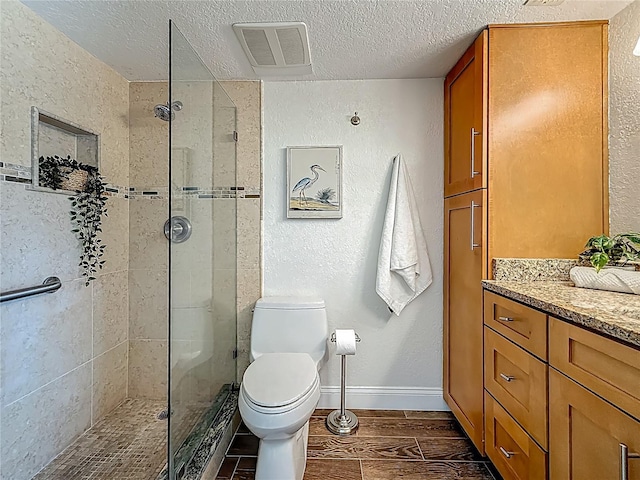 105 4th Ave NE Unit 426, Saint Petersburg, FL 33701 - bathroom with tiled shower, a textured ceiling, wood finished floors, and vanity