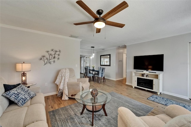 1813 Allegheny Dr, Sun City Center, FL 33573 - living area with a ceiling fan, wood finished floors, a textured ceiling, baseboards, and crown molding