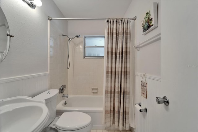 1813 Allegheny Dr, Sun City Center, FL 33573 - bathroom featuring shower / bathtub combination with curtain, toilet, a sink, and a wainscoted wall