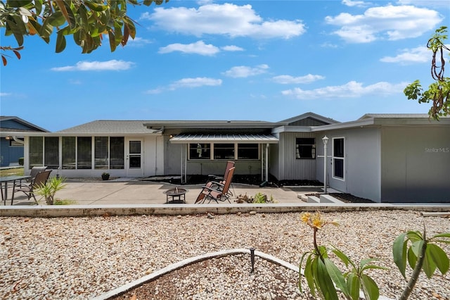 1813 Allegheny Dr, Sun City Center, FL 33573 - rear view of property with an outdoor fire pit, a patio, and a sunroom