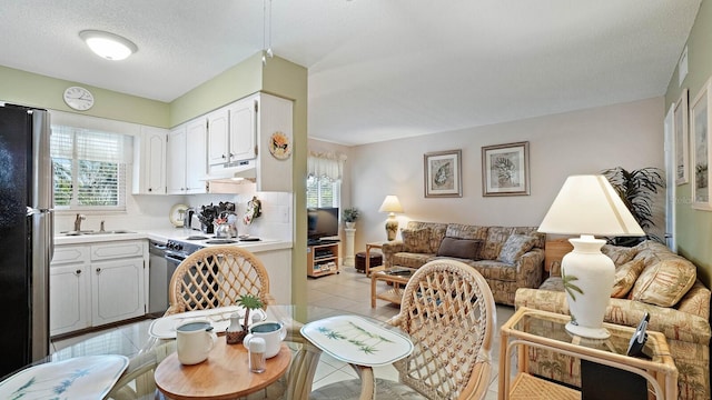 600 71st Ave Unit 16, St Pete Beach, FL 33706 - living room with plenty of natural light, light tile patterned flooring, and a textured ceiling
