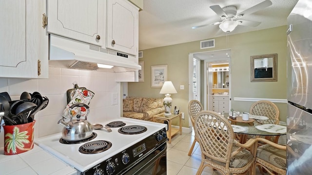 600 71st Ave Unit 16, St Pete Beach, FL 33706 - kitchen with electric range, under cabinet range hood, light countertops, white cabinetry, and a ceiling fan