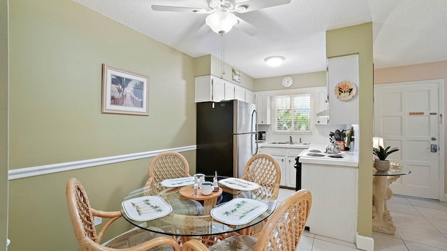 600 71st Ave Unit 16, St Pete Beach, FL 33706 - dining space with light tile patterned flooring, a ceiling fan, and a textured ceiling