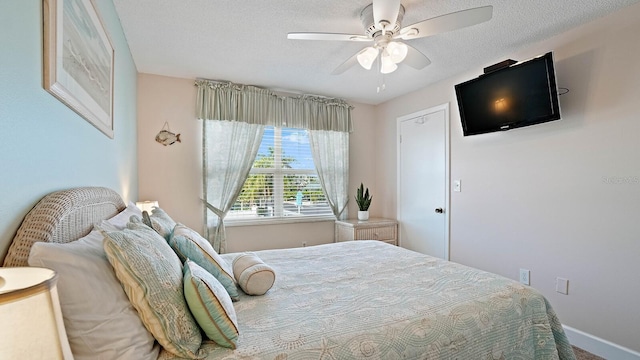 600 71st Ave Unit 16, St Pete Beach, FL 33706 - bedroom with ceiling fan, baseboards, and a textured ceiling