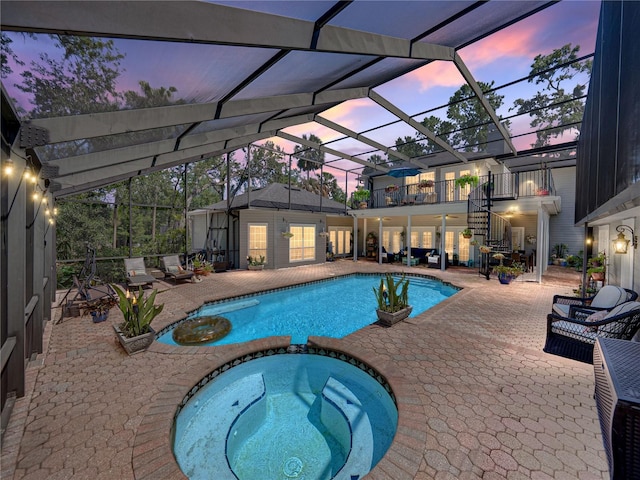4611 Ackerly Way, Brandon, FL 33511 - pool at dusk with a patio, a pool with connected hot tub, stairs, and a lanai