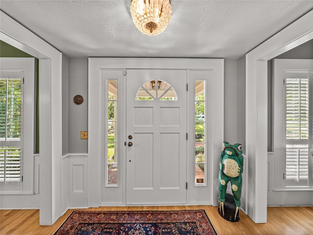 4611 Ackerly Way, Brandon, FL 33511 - entryway featuring a textured ceiling, wood finished floors, and a chandelier