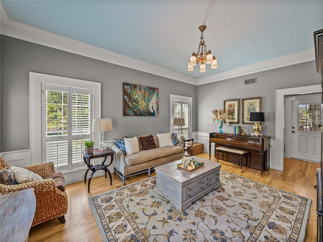 4611 Ackerly Way, Brandon, FL 33511 - living area with a chandelier, crown molding, light wood-style floors, and a wainscoted wall