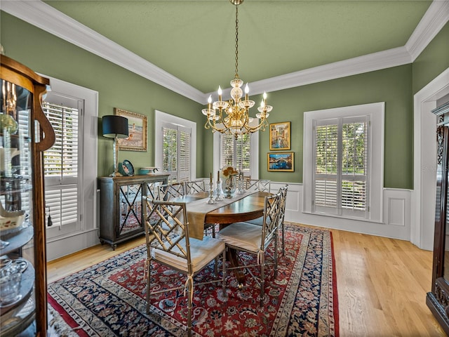 4611 Ackerly Way, Brandon, FL 33511 - dining area featuring a chandelier, crown molding, a wainscoted wall, and wood finished floors