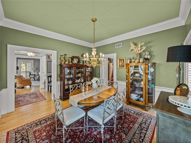 4611 Ackerly Way, Brandon, FL 33511 - dining area with ornamental molding, a chandelier, wood finished floors, and wainscoting