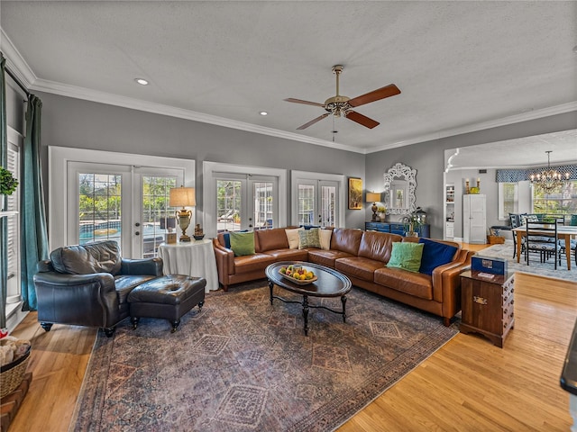 4611 Ackerly Way, Brandon, FL 33511 - living room featuring french doors, light wood-style floors, a ceiling fan, a chandelier, and crown molding