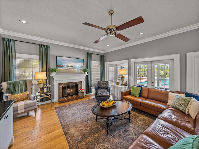 4611 Ackerly Way, Brandon, FL 33511 - living room featuring crown molding, a ceiling fan, light wood-type flooring, french doors, and a brick fireplace