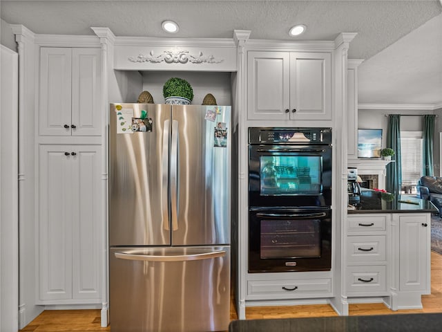 4611 Ackerly Way, Brandon, FL 33511 - kitchen with freestanding refrigerator, white cabinetry, a textured ceiling, dark countertops, and light wood finished floors