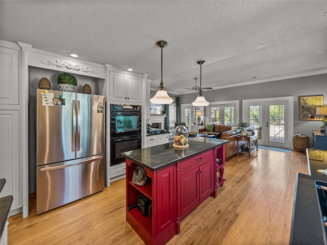 4611 Ackerly Way, Brandon, FL 33511 - kitchen featuring freestanding refrigerator, open floor plan, light wood-type flooring, a textured ceiling, and ornamental molding