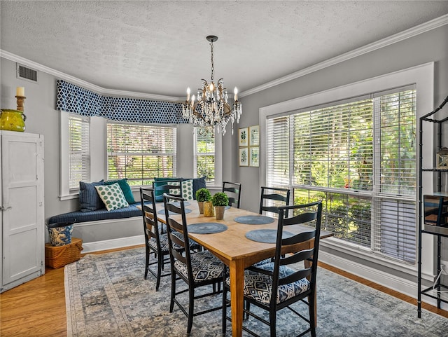 4611 Ackerly Way, Brandon, FL 33511 - dining area with a textured ceiling, healthy amount of natural light, wood finished floors, crown molding, and a chandelier