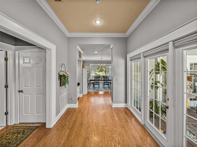 4611 Ackerly Way, Brandon, FL 33511 - entrance foyer featuring light wood-type flooring, crown molding, a chandelier, and a textured ceiling