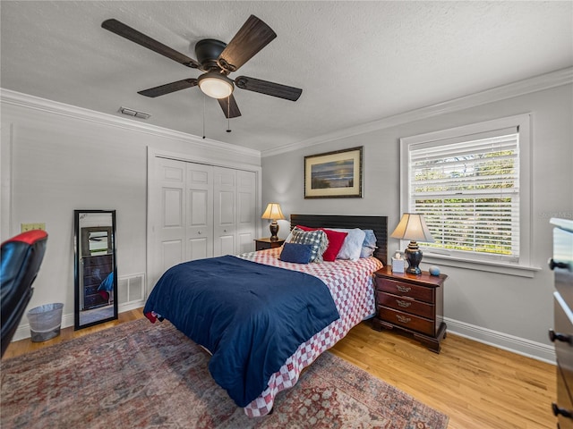 4611 Ackerly Way, Brandon, FL 33511 - bedroom with ornamental molding, wood finished floors, a closet, a ceiling fan, and a textured ceiling