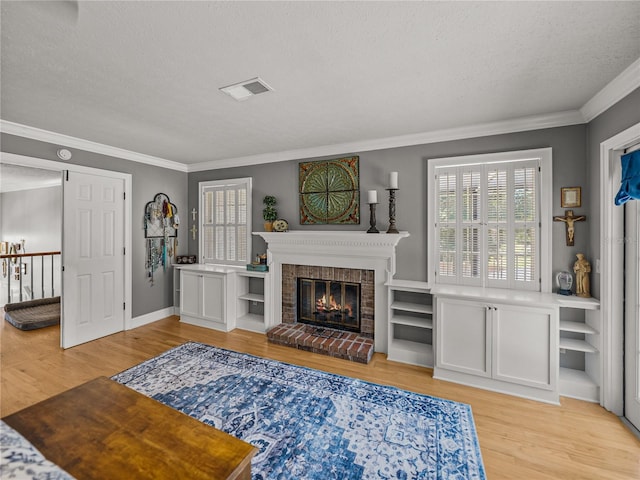 4611 Ackerly Way, Brandon, FL 33511 - living room with a textured ceiling, light wood finished floors, ornamental molding, and a brick fireplace