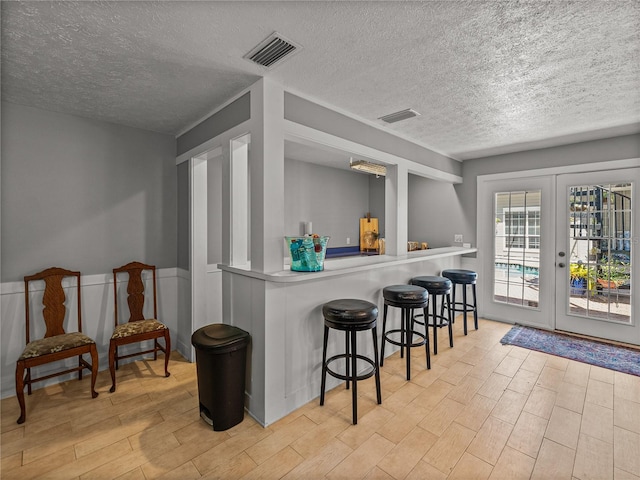 4611 Ackerly Way, Brandon, FL 33511 - indoor bar featuring light wood-style flooring, a textured ceiling, and french doors