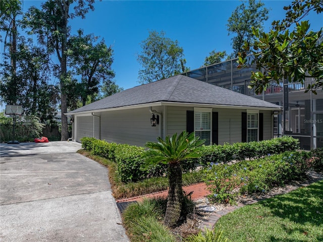 4611 Ackerly Way, Brandon, FL 33511 - view of side of property featuring driveway, a shingled roof, and an attached garage