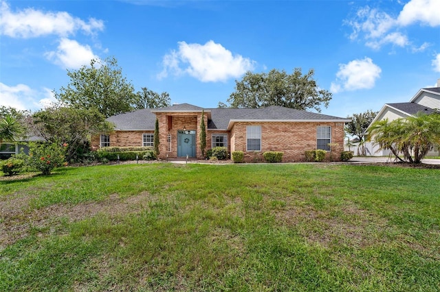 10421 Mesa Ln, Clermont, FL 34711 - view of front of property with brick siding, a front lawn, and a shingled roof