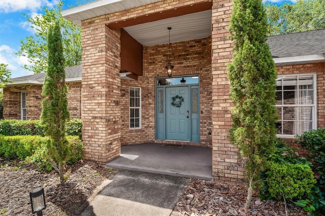 10421 Mesa Ln, Clermont, FL 34711 - view of exterior entry with brick siding and roof with shingles