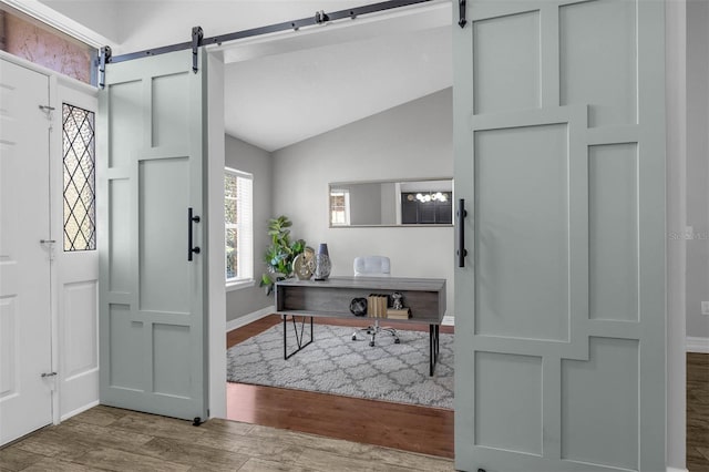10421 Mesa Ln, Clermont, FL 34711 - foyer with a barn door, wood finished floors, lofted ceiling, and baseboards