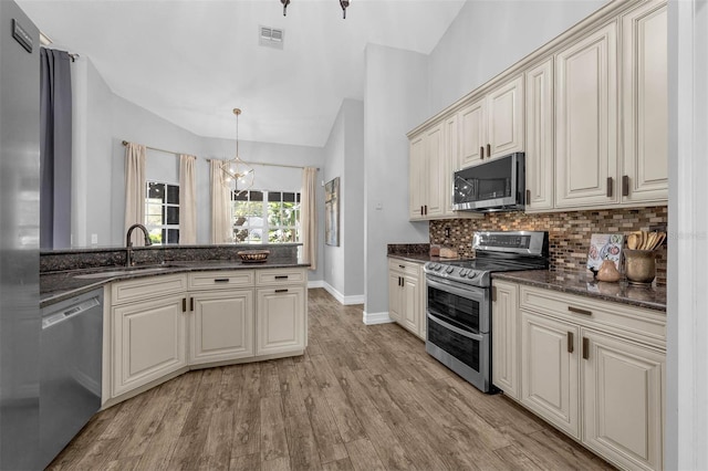 10421 Mesa Ln, Clermont, FL 34711 - kitchen featuring stainless steel appliances, a sink, backsplash, lofted ceiling, and light wood-style flooring
