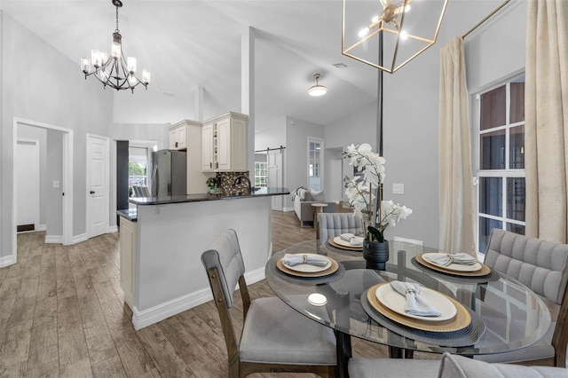 10421 Mesa Ln, Clermont, FL 34711 - dining room with a chandelier, high vaulted ceiling, light wood-style flooring, and baseboards