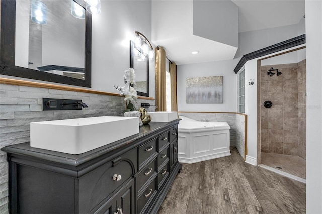 10421 Mesa Ln, Clermont, FL 34711 - bathroom with tile walls, wood finished floors, a garden tub, tiled shower, and a wainscoted wall