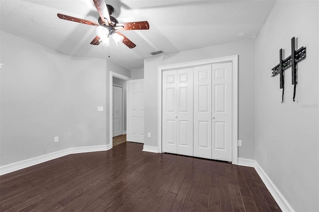 10421 Mesa Ln, Clermont, FL 34711 - unfurnished bedroom featuring dark wood-style flooring, baseboards, a closet, ceiling fan, and a textured ceiling