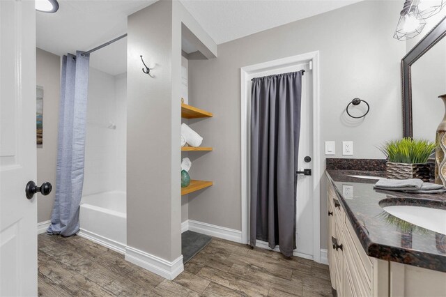 10421 Mesa Ln, Clermont, FL 34711 - bathroom with wood finished floors, double vanity, shower / tub combo with curtain, and baseboards