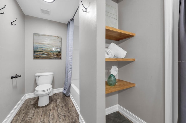 10421 Mesa Ln, Clermont, FL 34711 - full bathroom with wood finished floors, toilet, baseboards, and shower / bathtub combination with curtain