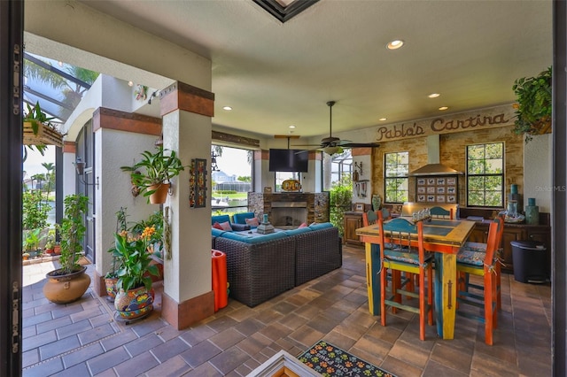 5417 Tybee Island Dr, Apollo Beach, FL 33572 - living room with ceiling fan, a stone fireplace, healthy amount of natural light, and recessed lighting