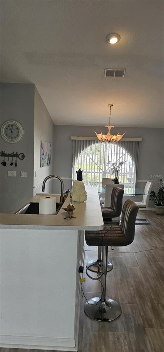 4500 Onorio St, New Port Richey, FL 34653 - kitchen featuring a chandelier, wood finished floors, and light countertops