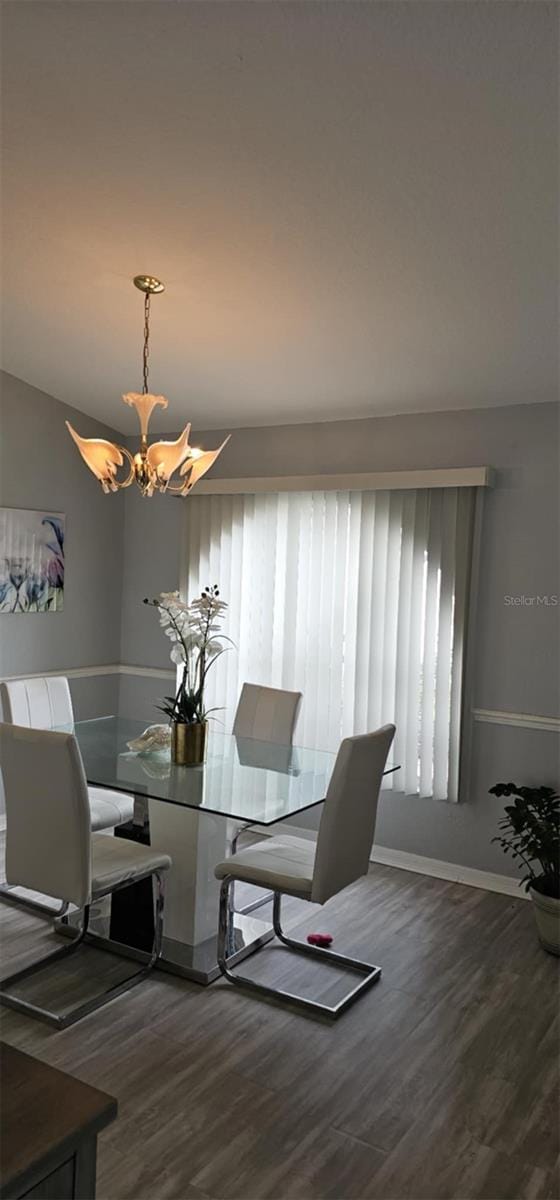 4500 Onorio St, New Port Richey, FL 34653 - dining space featuring a chandelier, wood finished floors, and baseboards