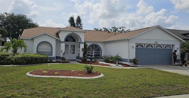 4500 Onorio St, New Port Richey, FL 34653 - mediterranean / spanish home with french doors, an attached garage, stucco siding, a front yard, and driveway