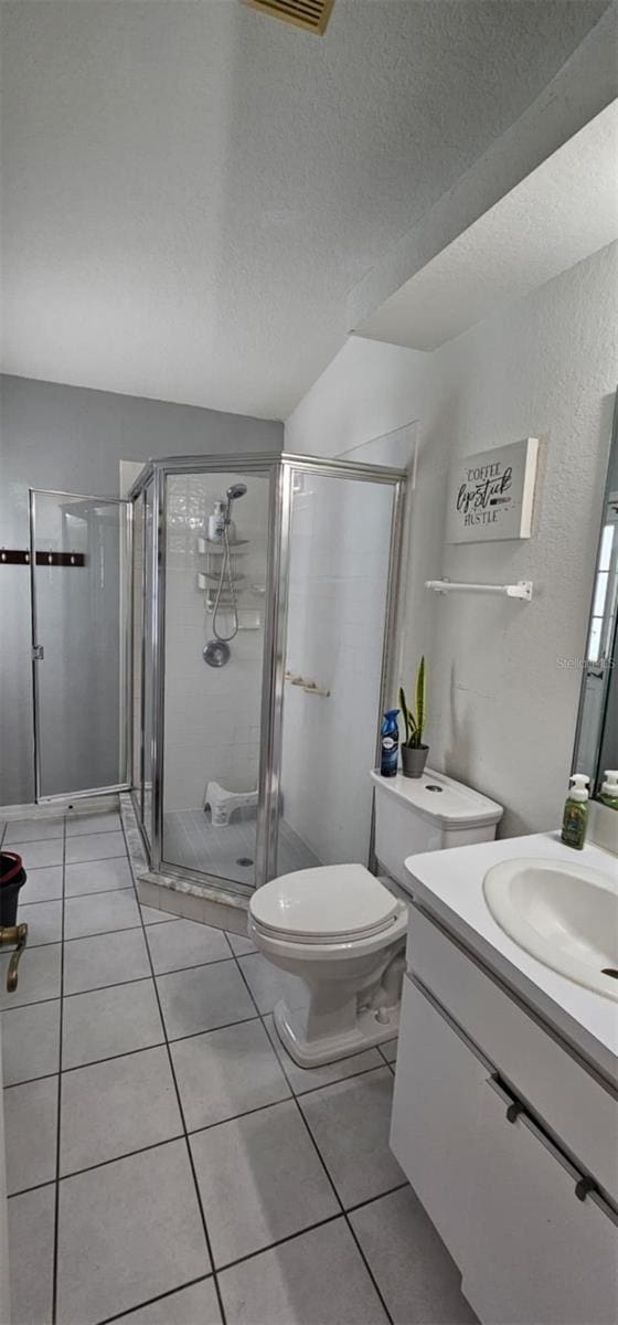 4500 Onorio St, New Port Richey, FL 34653 - full bathroom with vanity, a stall shower, toilet, tile patterned floors, and a textured ceiling