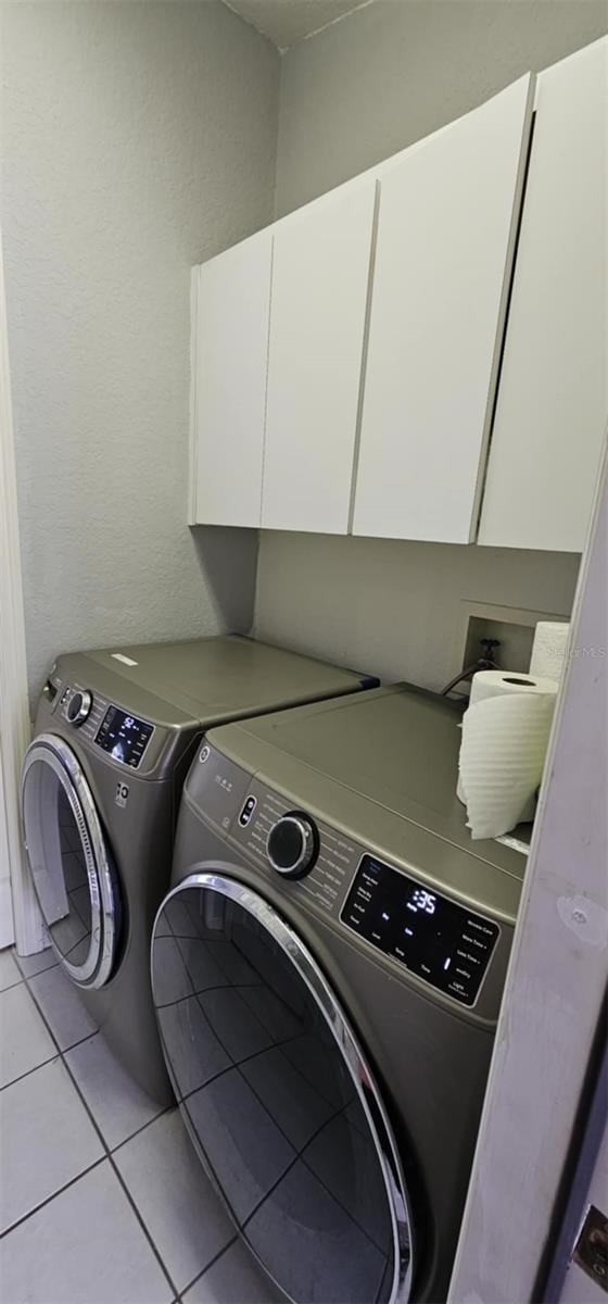 4500 Onorio St, New Port Richey, FL 34653 - laundry room featuring cabinet space, washer and dryer, and light tile patterned floors