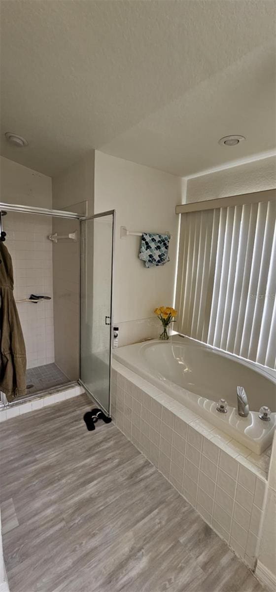 4500 Onorio St, New Port Richey, FL 34653 - bathroom with a garden tub, a shower stall, and wood finished floors