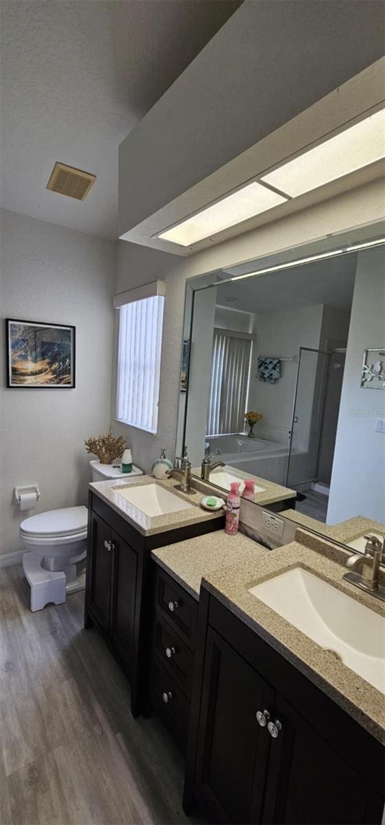4500 Onorio St, New Port Richey, FL 34653 - full bath with wood finished floors, vanity, toilet, and baseboards