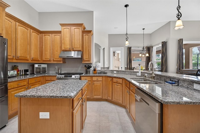 111 Falling Water Dr, Brandon, FL 33511 - kitchen with under cabinet range hood, stainless steel appliances, a kitchen island, dark stone countertops, and a peninsula