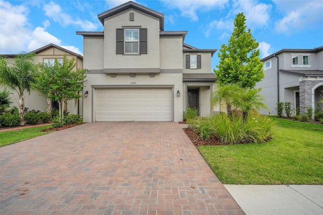 19238 Old Spanish Rd, Tampa, FL 33647 - view of front of property featuring decorative driveway, stucco siding, a front lawn, and a garage