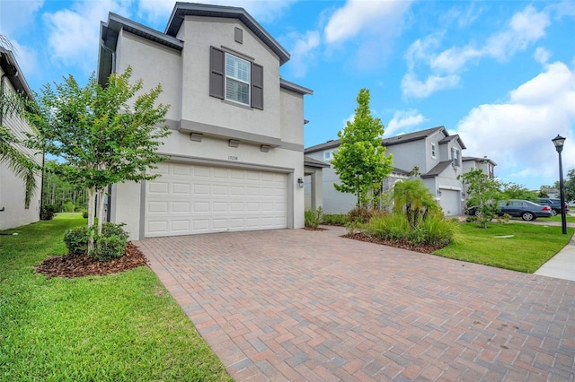 19238 Old Spanish Rd, Tampa, FL 33647 - view of front of house featuring stucco siding, decorative driveway, an attached garage, and a front yard