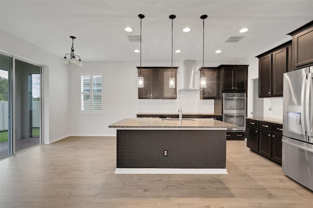 19238 Old Spanish Rd, Tampa, FL 33647 - kitchen featuring stainless steel appliances, wall chimney exhaust hood, decorative backsplash, a sink, and light stone countertops