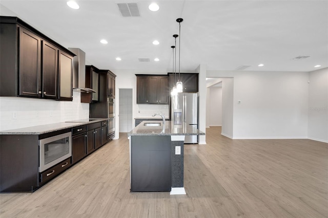 19238 Old Spanish Rd, Tampa, FL 33647 - kitchen featuring wall chimney exhaust hood, stainless steel appliances, backsplash, a sink, and light stone countertops