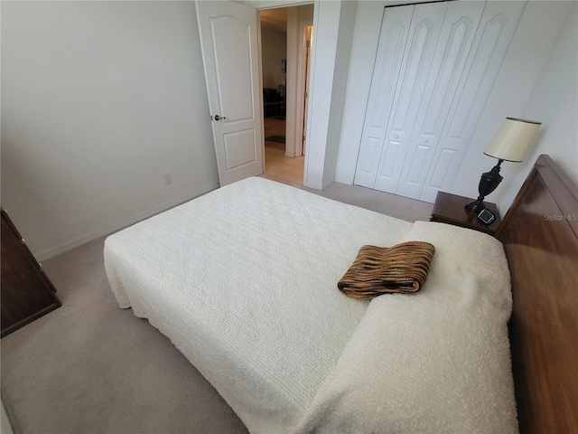 611 Tremont Greens Ln, Sun City Center, FL 33573 - bedroom featuring light colored carpet, a closet, and baseboards