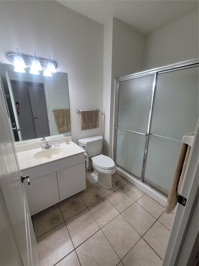 611 Tremont Greens Ln, Sun City Center, FL 33573 - bathroom with vanity, toilet, a shower with shower door, and tile patterned floors
