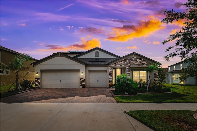 3091 King Fern Dr, Wimauma, FL 33598 - single story home with decorative driveway, stone siding, stucco siding, an attached garage, and a front yard